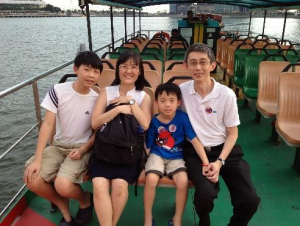A family of four sitting together on a boat on the water in Singapore