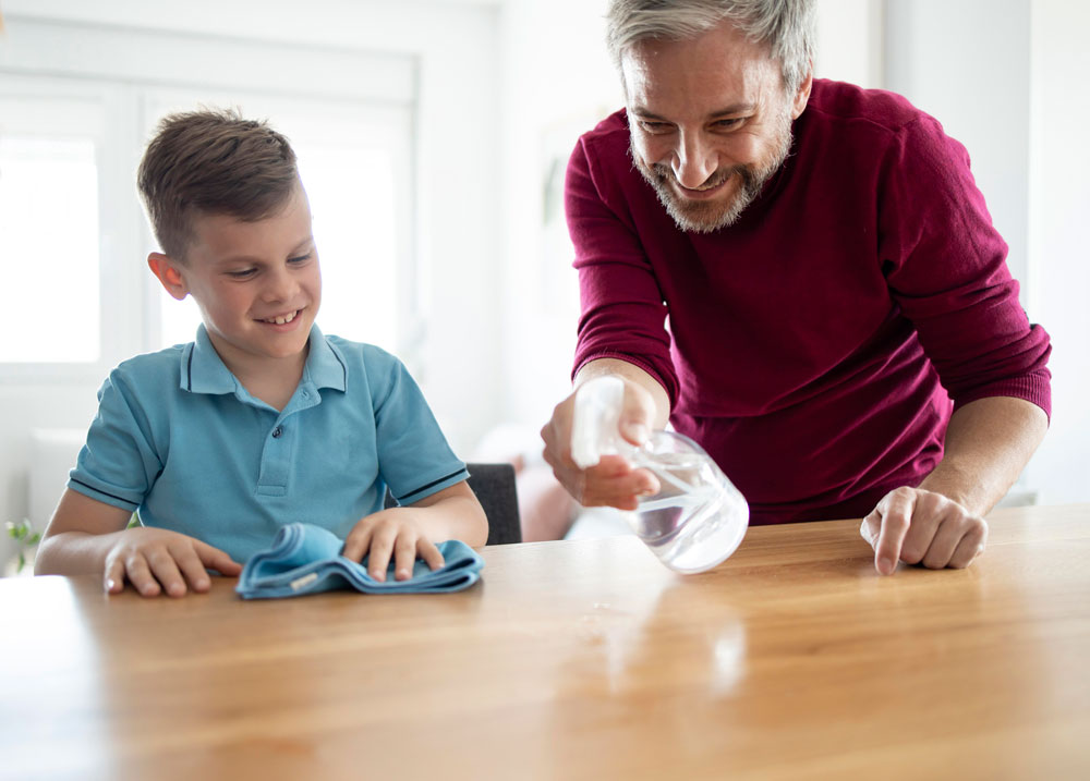 A father and son cleaning a table together